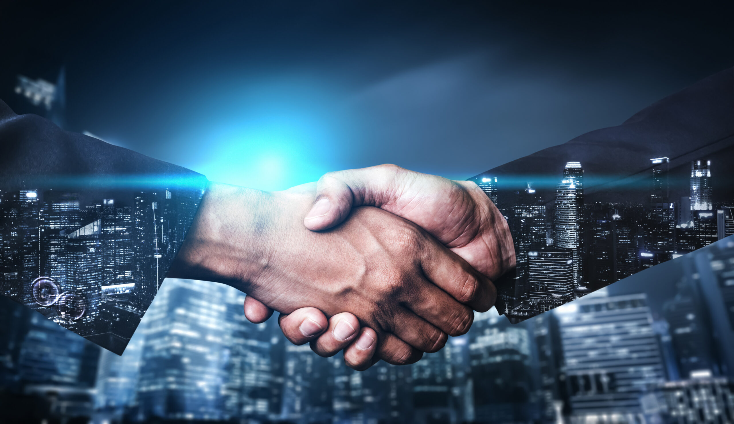 Double exposure image of business people handshake on city office building in background showing partnership success of business deal. Concept of corporate teamwork, trust partner and work agreement.