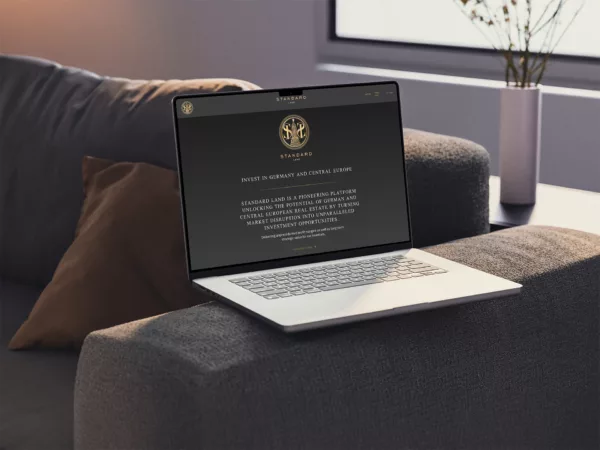 Standard Land Website MacBook on Couch Mockup